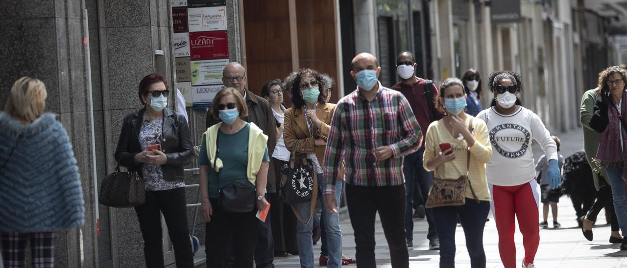 Personas con mascarillas por la calle.