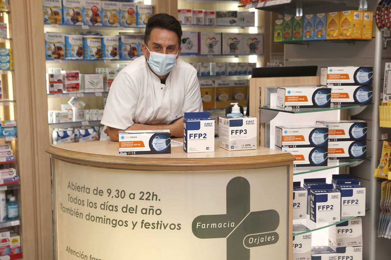 Un farmacéutico de Coia muestra los distintos tipos de mascarillas que se venden en su establecimiento