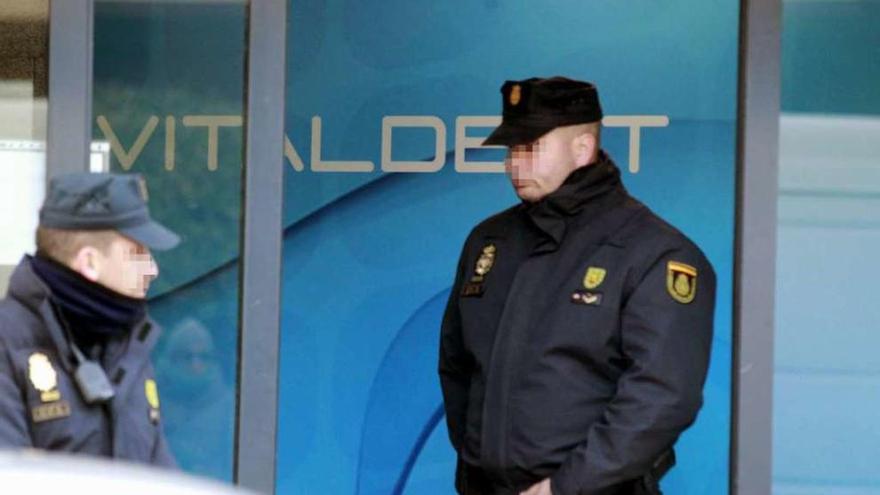 Dos policías, ayer, durante el registro de una clínica Vitaldent en Madrid.