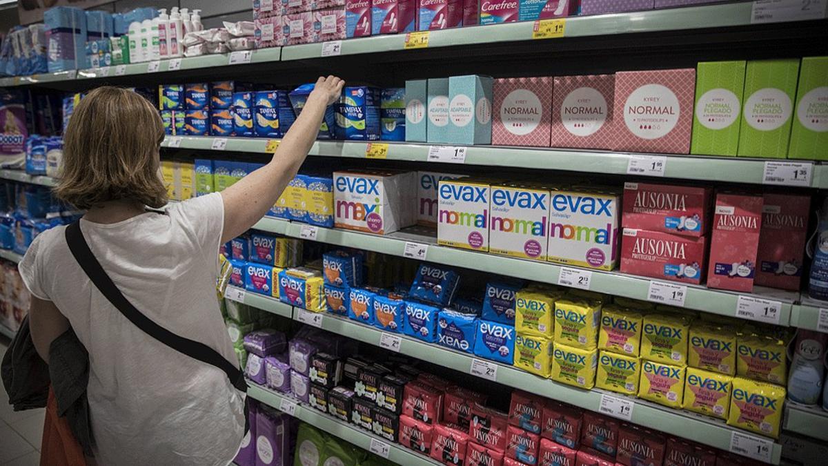 Una mujer compra productos para la menstruación en un supermercado de Barcelona
