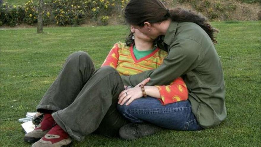 Una pareja se besa en un parque. / efe