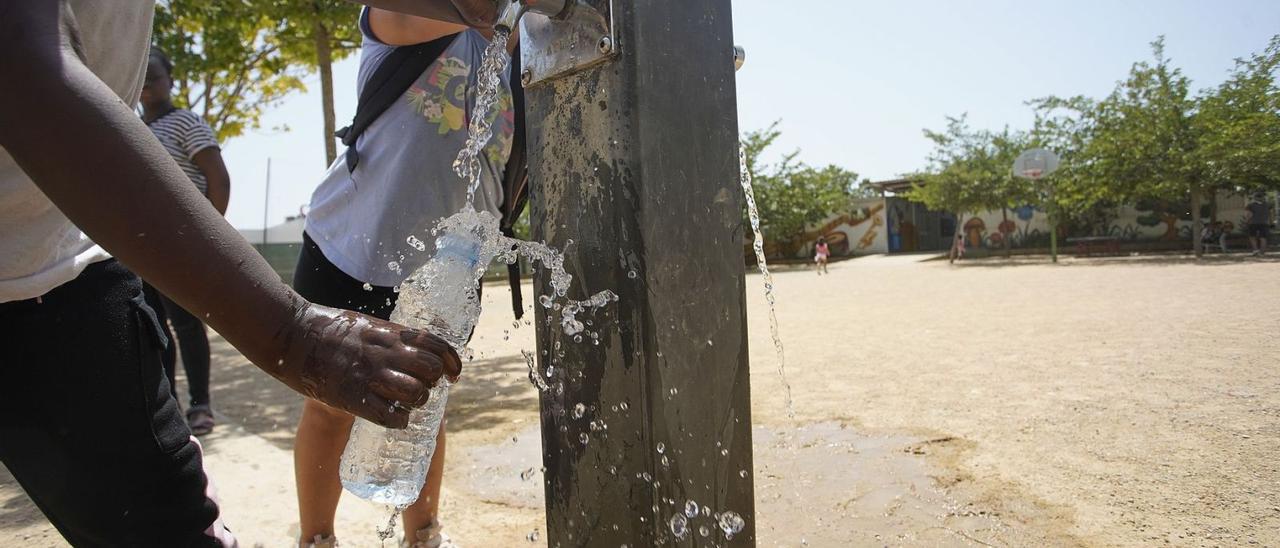 Dos alumnes de l’escola El Gegant del Rec de Salt, reomplint les ampolles d’aigua. | MARC MARTÍ