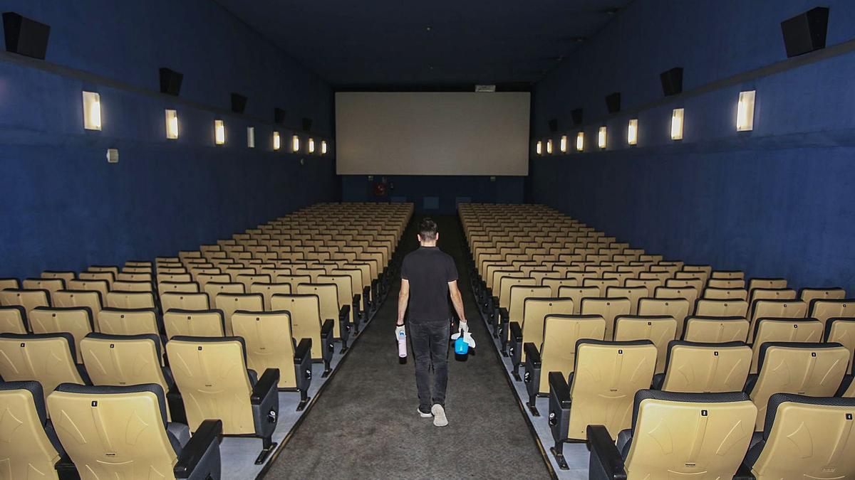 Un trabajador se dispone a limpiar el interior de una sala en los cines Aana San Juan.