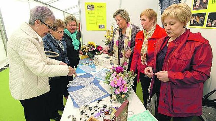 Visitantes, en uno de los stands participantes en la I Feria del Comercio y el Asociacionismo Local de Langreo.