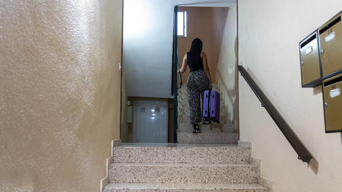 Una joven completa, maleta en mano, lo último de su mudanza hacia una nueva vivienda.