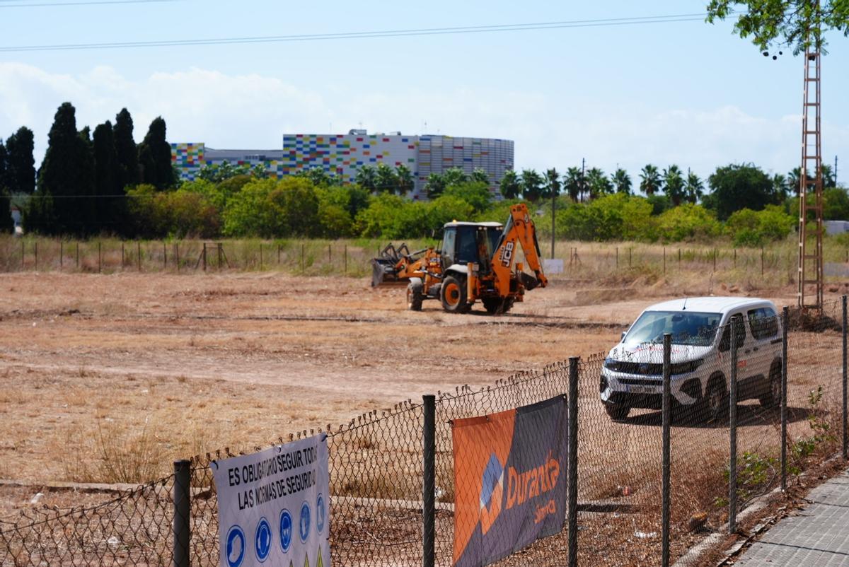 Una máquina dentro del terreno y al fondo el Palau de la Festa, este lunes.