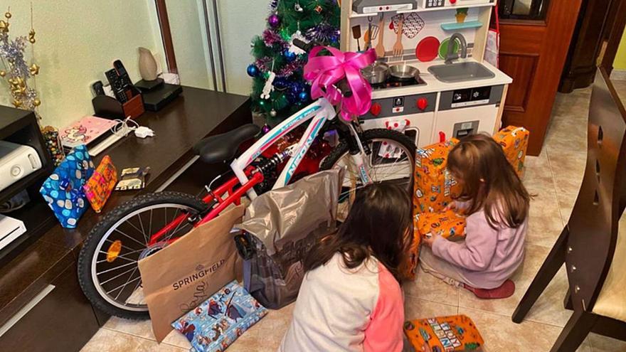 Dos niñas abriendo sus regalos de Reyes. | E. P.