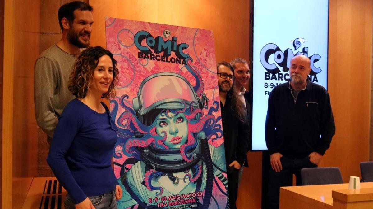 Meritxell Puig y parte del equipo del Cómic Barcelona, ante el cartel de la 38ª edición, obra de Belén Ortega.