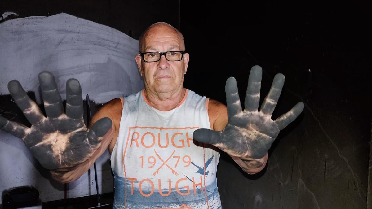 Paco Guzmán muestra sus manos ennegrecidas durante la limpieza de la vivienda.