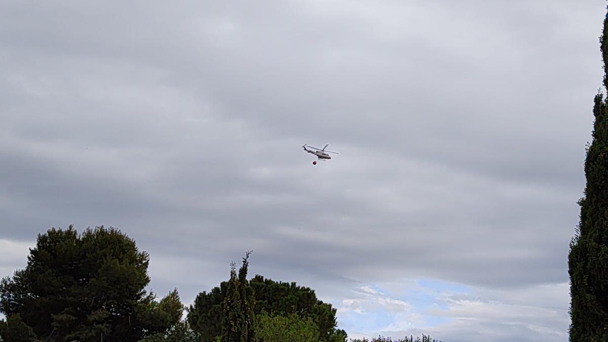 Un helicóptero sobre el incendio de Alfarp.