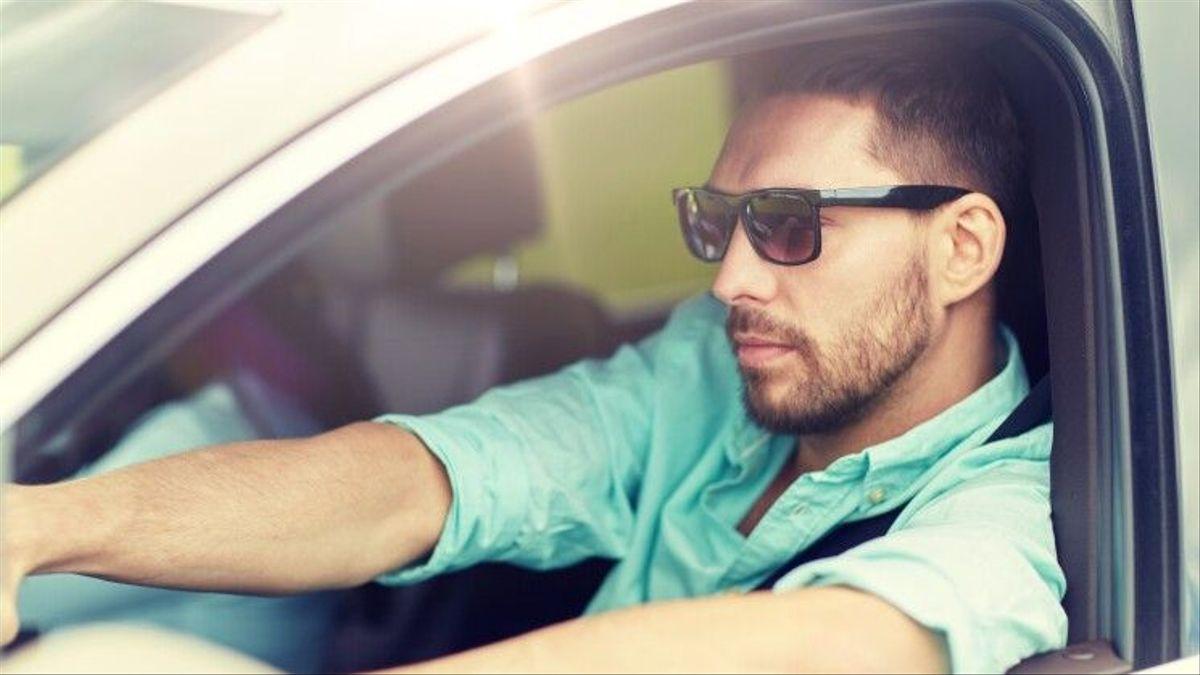 Un home conduïnt amb unes ulleres de sol