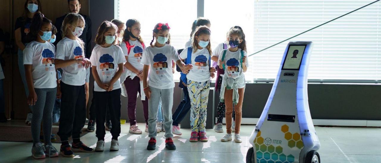 Un grupo de niños contempla a Marysol en plena faena durante su visita al ITER .