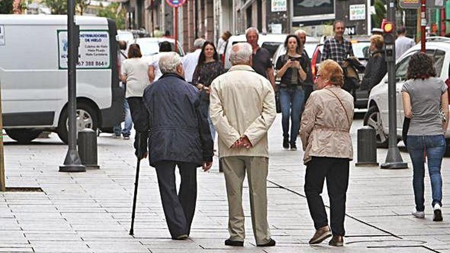 Personas mayores caminan por una calle.