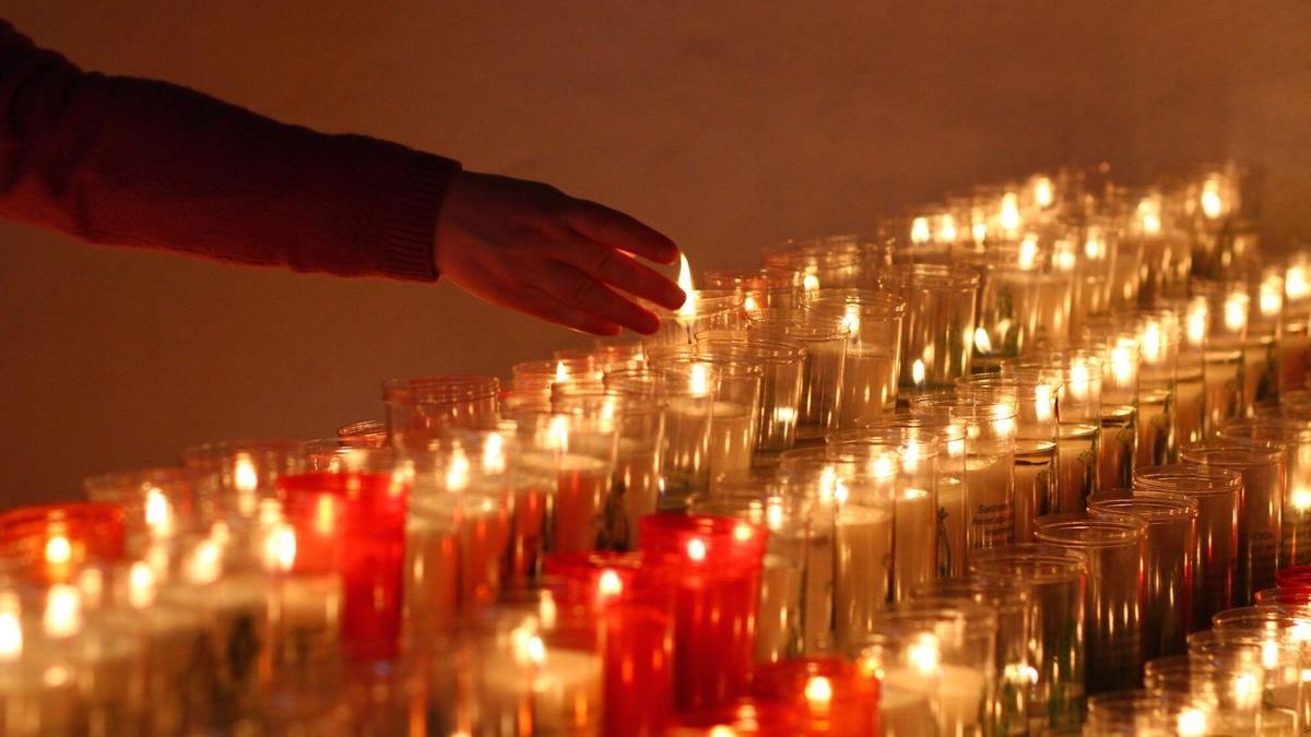 Velas encendidas con peticiones de los feligreses.