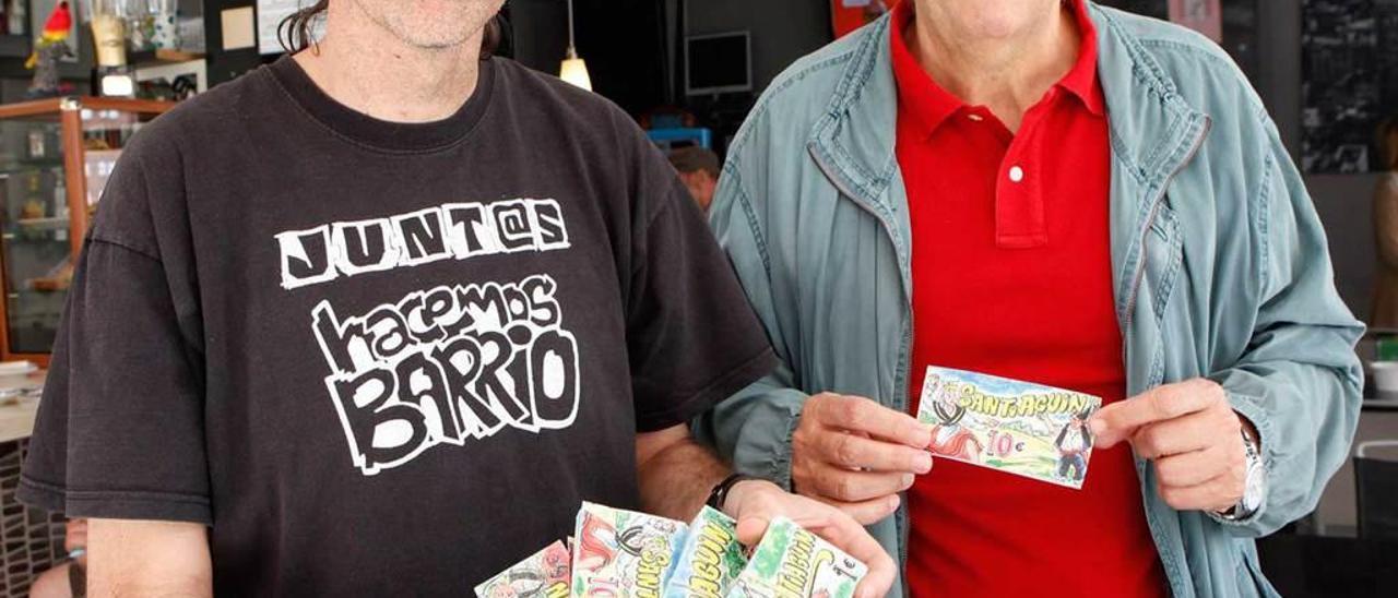 Roberto Porras y Enrique Pañeda muestran billetes de santiaguín.