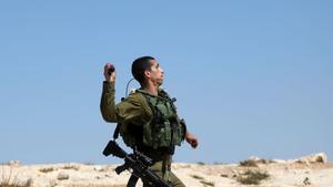 Un Policía israelí lanzando un objeto contra manifestantes palestinos.