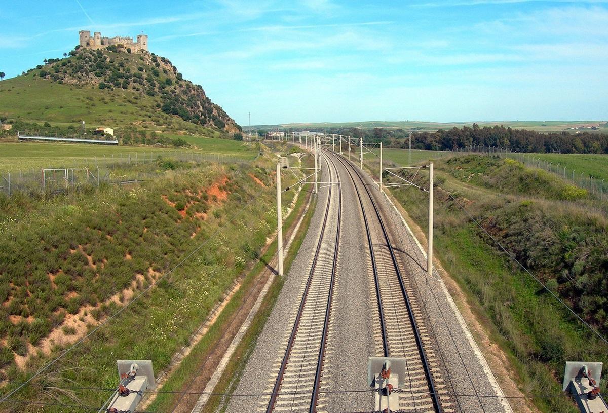 La línea ferroviaria de alta velocidad a su paso por Almodóvar del Río, con el emblemático castillo de esta localidad cordobesa al fondo.