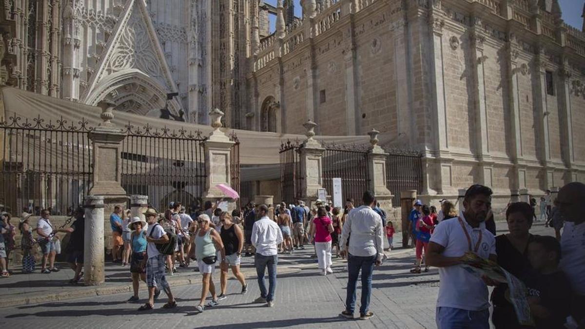 Turistas pasean y hacen cola en el entorno de la Catedral de Sevilla