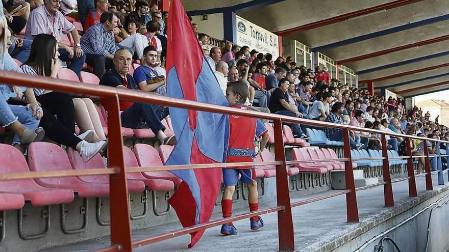 Un joven aficionado de la UD Ourense porta una bandera en la grada de tribuna. // Jesús Regal