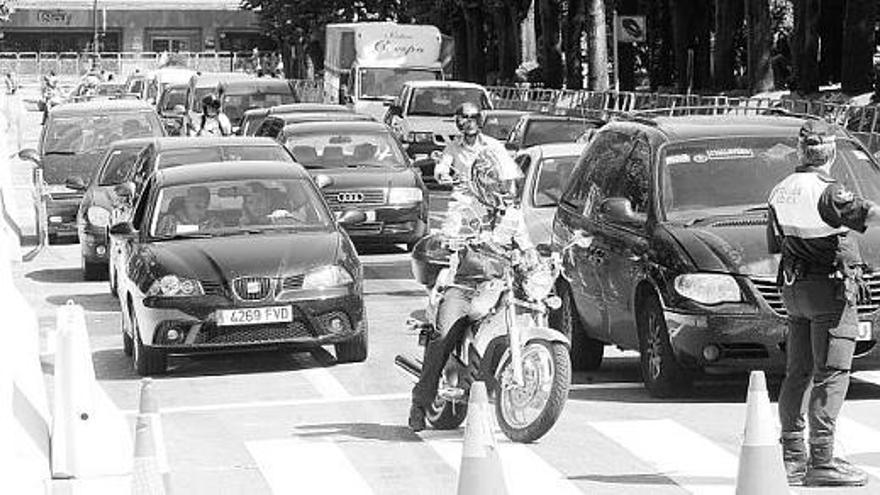 Un policía corta el tráfico, ayer, en la calle Toreno, durante la colocación de los bloques de hormigón que delimitarán el circuito urbano.