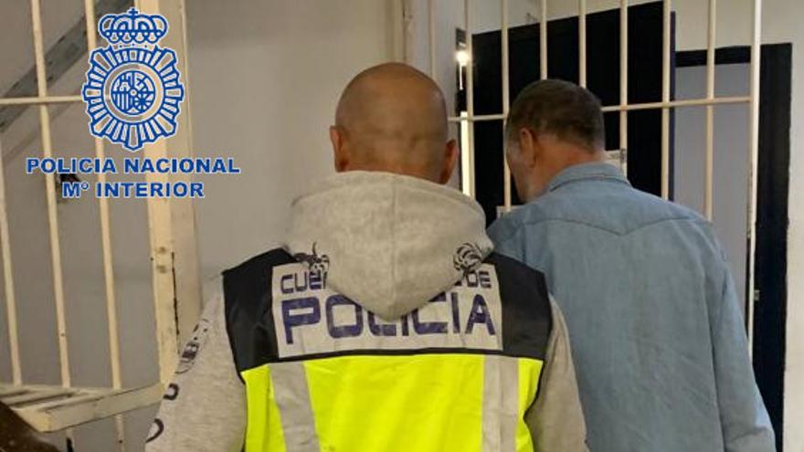 Un policía custodia al presunto pirómano detenido.