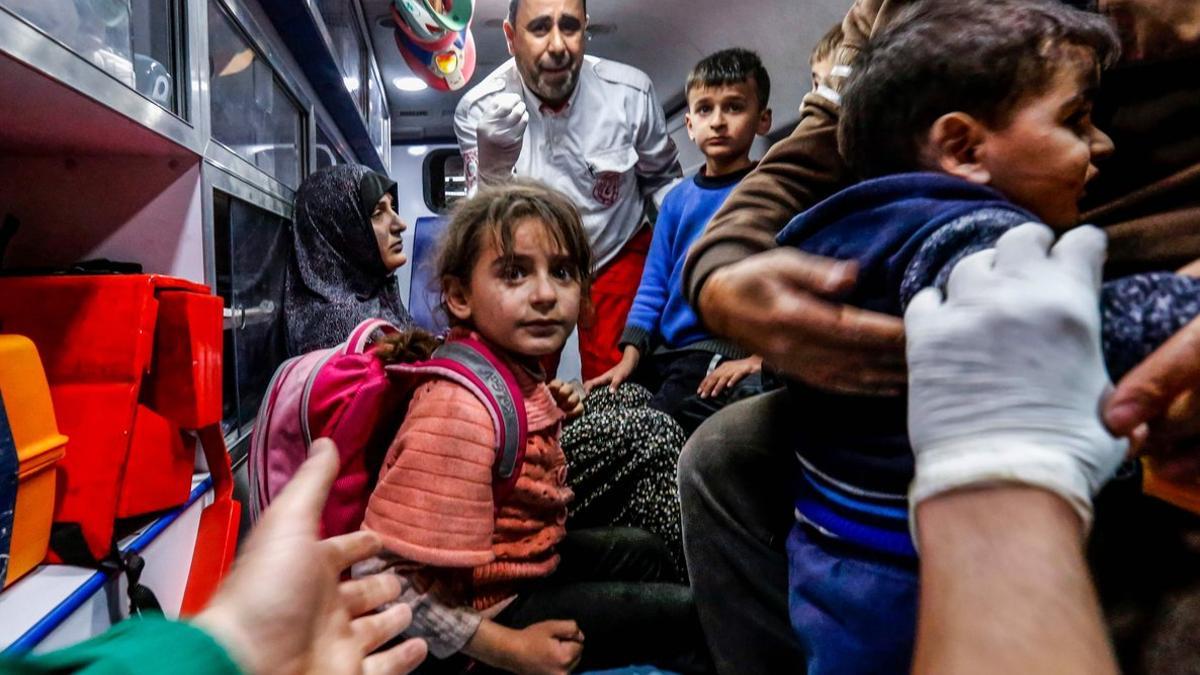 Una familia palestina espera asistencia médica frente a un hospital de Gaza.