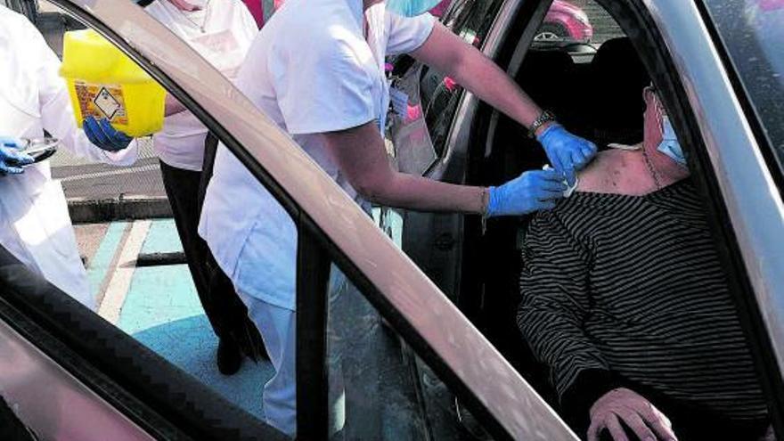 Una enfermera vacuna a un paciente sentado en un automóvil. |  // ORIOL CLAVERA