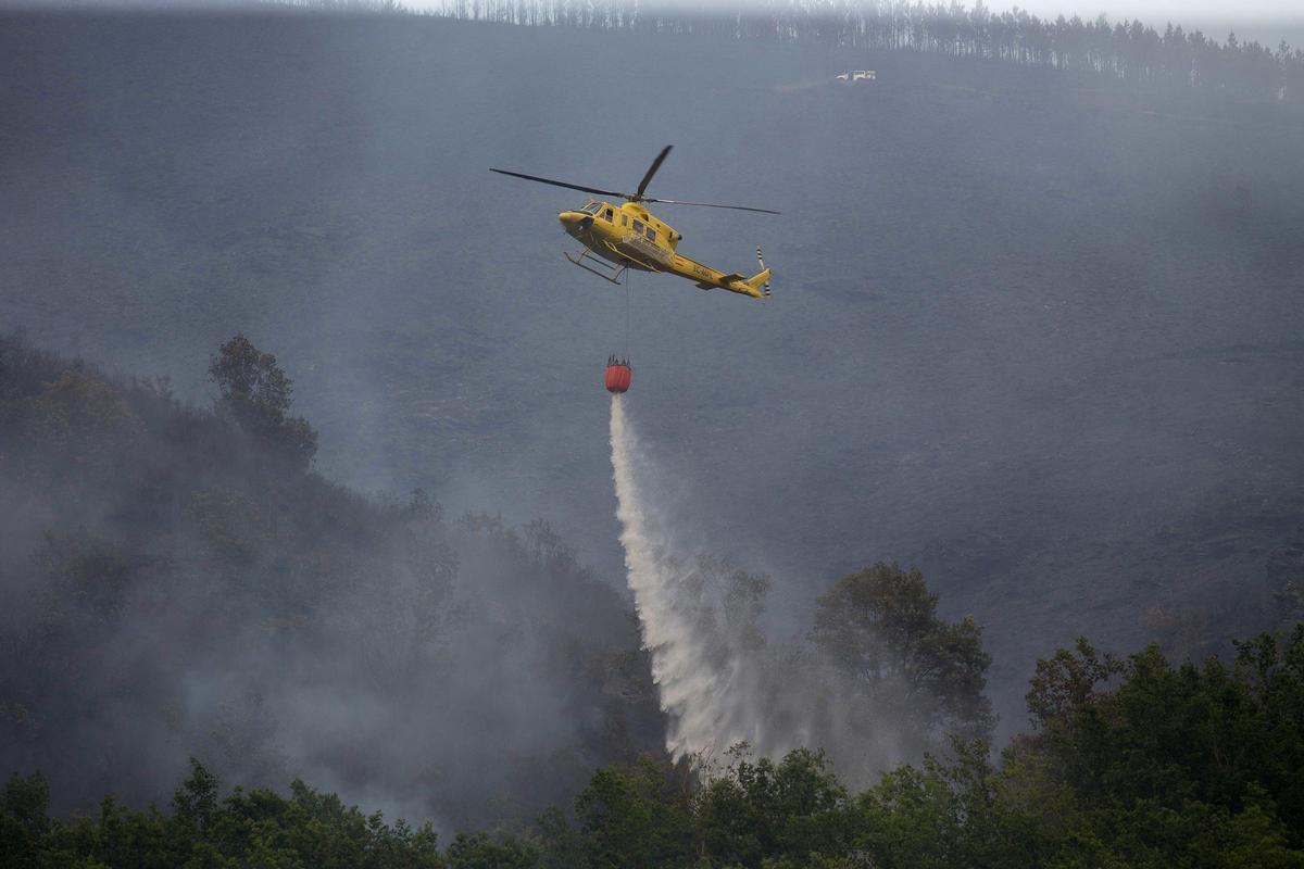Archivo - Labores de extinción del incendio forestal que se originó la pasada madrugada en el entorno de la localidad de Ferreirós de Abaixo, en el municipio de Folgoso do Courel, a 12 de junio de 2021, en Lugo, Galicia (España).