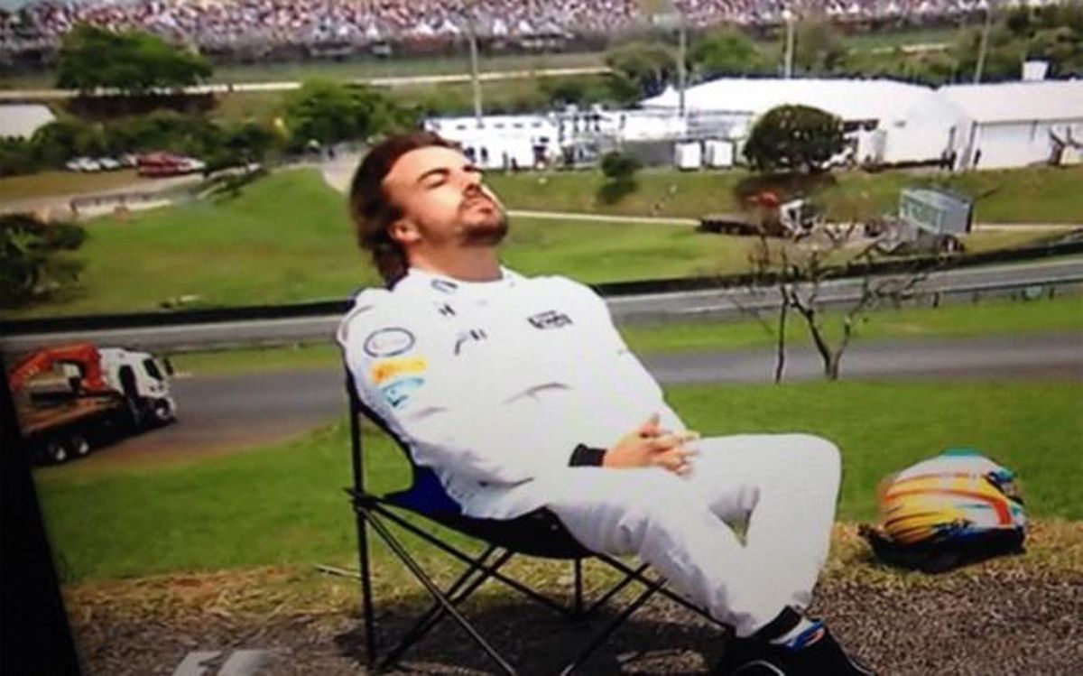 Fernando Alonso toma el sol después de que el coche se le vuelva a par
