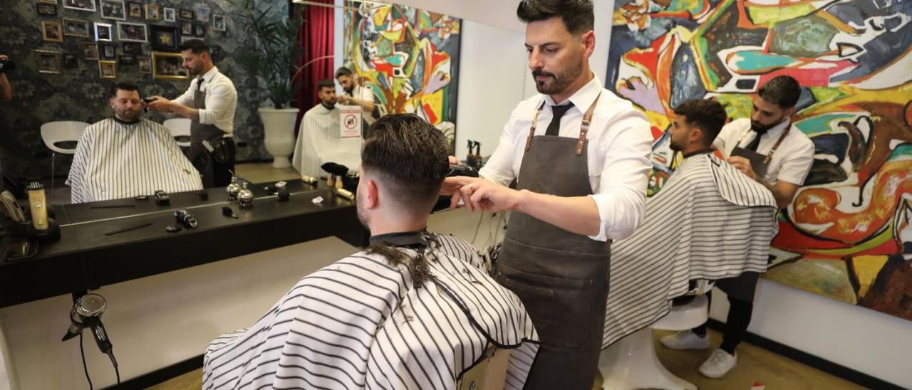 Abel Pleguezuelos y el equipo de la barbería recién premiada, ayer, en el establecimiento.  | ANTONIO AMORÓS