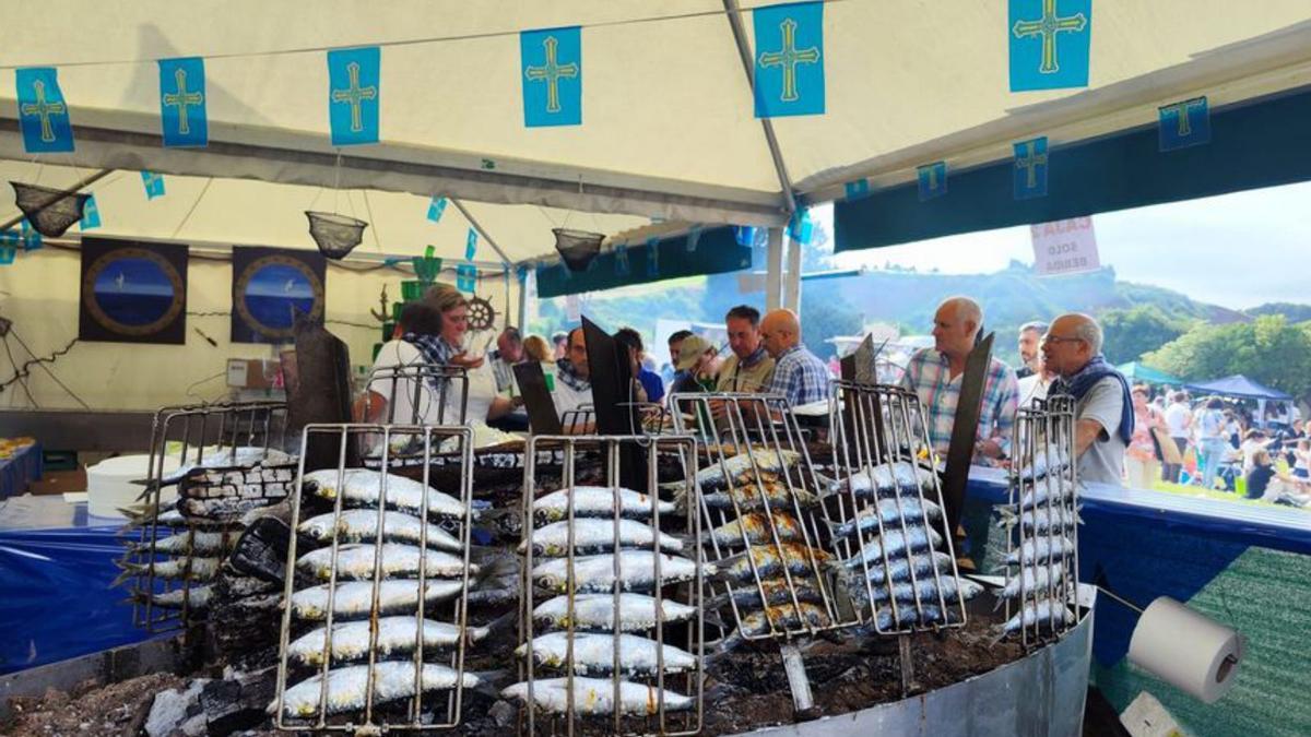 1.-Sardinas en espeto preparadas por el restaurante Varadero. 2.-La plantilla de El Llagarín celebra la victoria como ganadora del festival. 3.-Los cocineros del Llagar de Pola trabajando sin descanso. 4.-El prao del paseo de San Antonio repleto de asistentes.  5.-Mercedes Martínez, con un plato de sardinas, acompañada de su familia.  |  | A. G.-O.