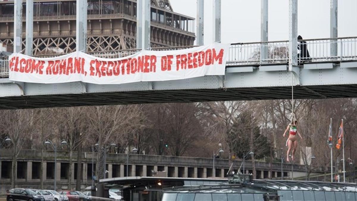 Sarah Constantin, activista de Femen, colgada de un puente de París, cerca de la torre Eiffel, este jueves.