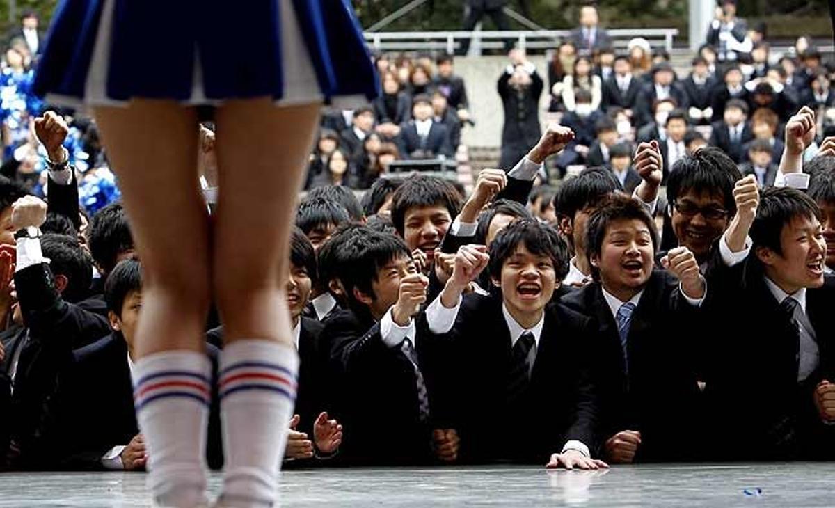 Un grup d’estudiants universitaris japonesos observen una animadora en una actuació a Tòquio (Japó).