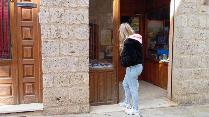 Una joven  mira un escaparate de una librería de la localidad toresana. | I. A.