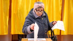 Una mujer deposita su papeleta en un colegio electoral de Mogosoaia durante las legislativas en Rumanía.