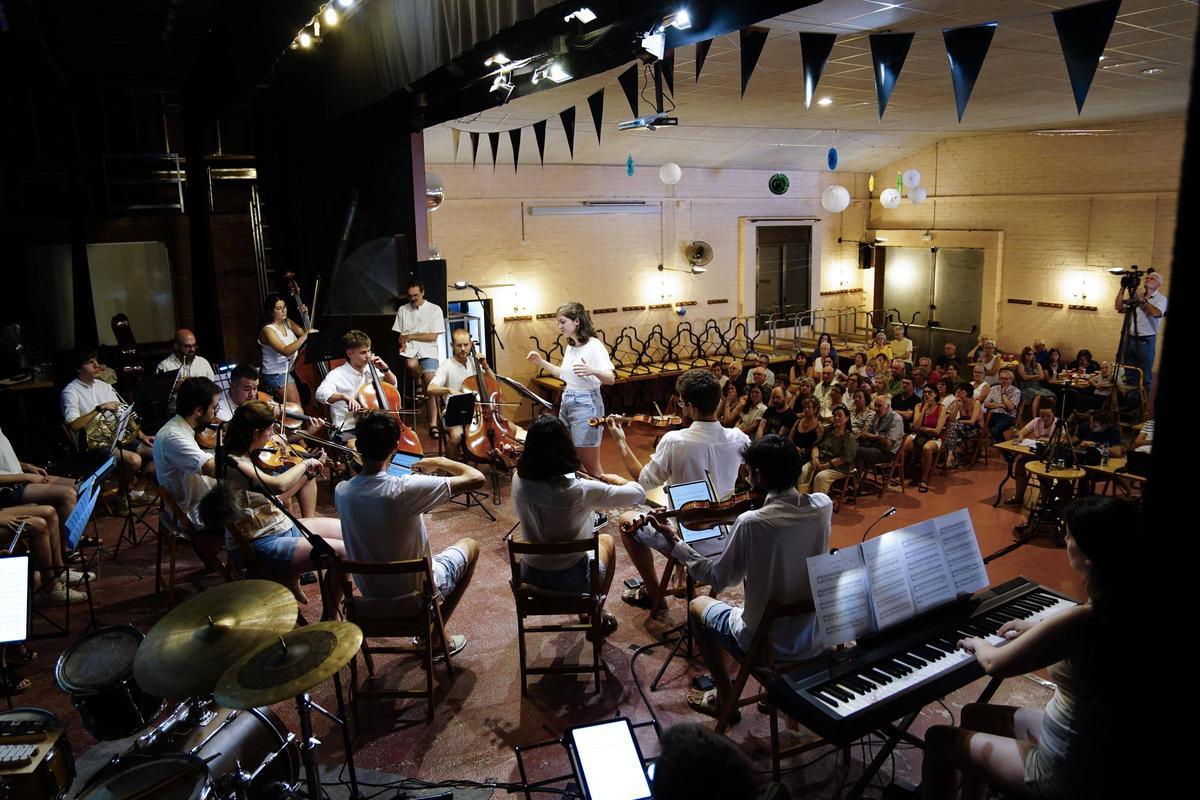 Sarró dirigint l'orquestra davant el públic que omplia el casal de Viladordis