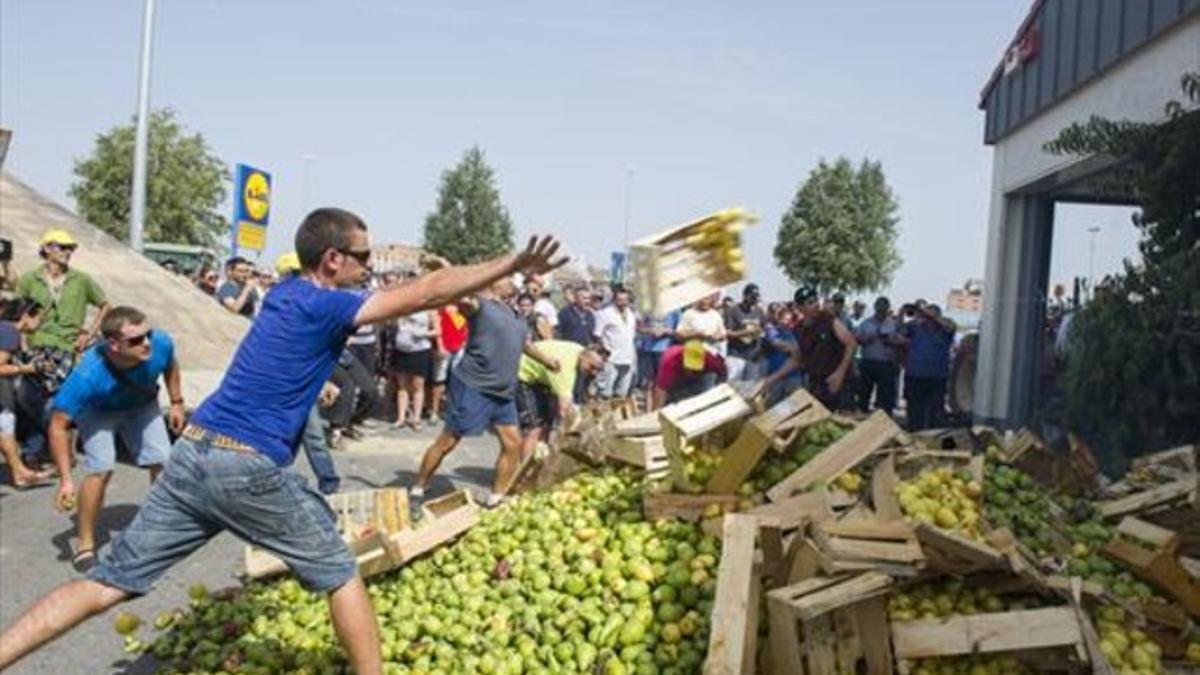 Unos payeses lanzan peras a las puertas de un híper en Lleida