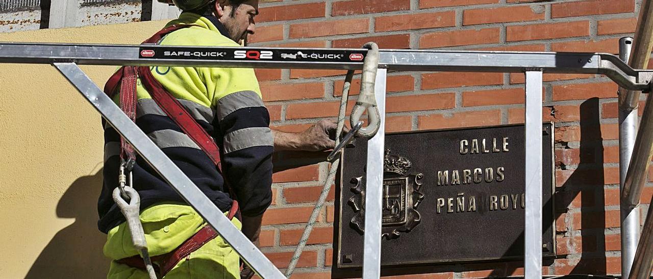 Un operario reponiendo la placa de la calle Marcos Peña Royo en enero del año pasado.