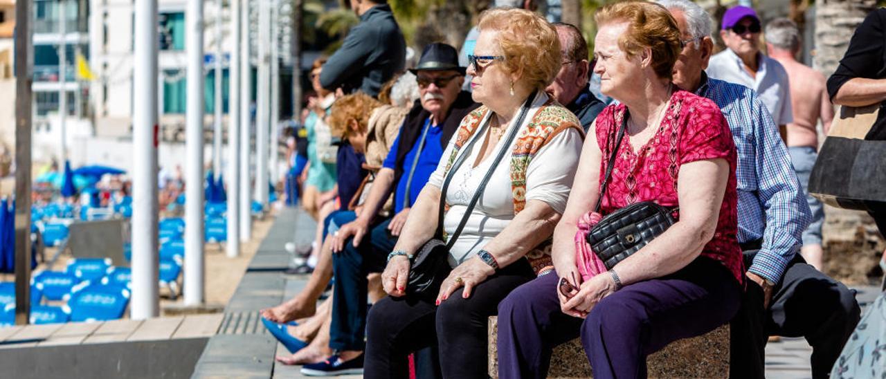 Turistas de la tercera edad toman el sol en el paseo de la playa de Levante de Benidorm, el pasado abril.