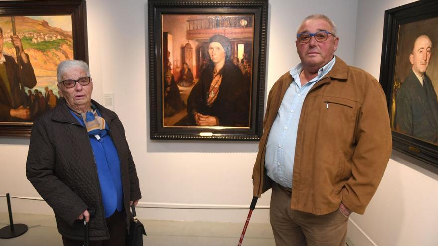 Aurea Pose y su hijo José, frente al retrato de su madre, Encarnación. |