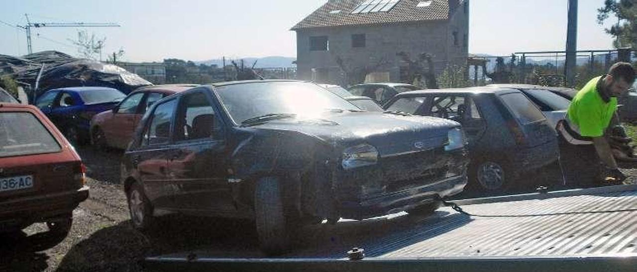 Traslado de coches abandonado en una finca de Coiro. // G.Núñez