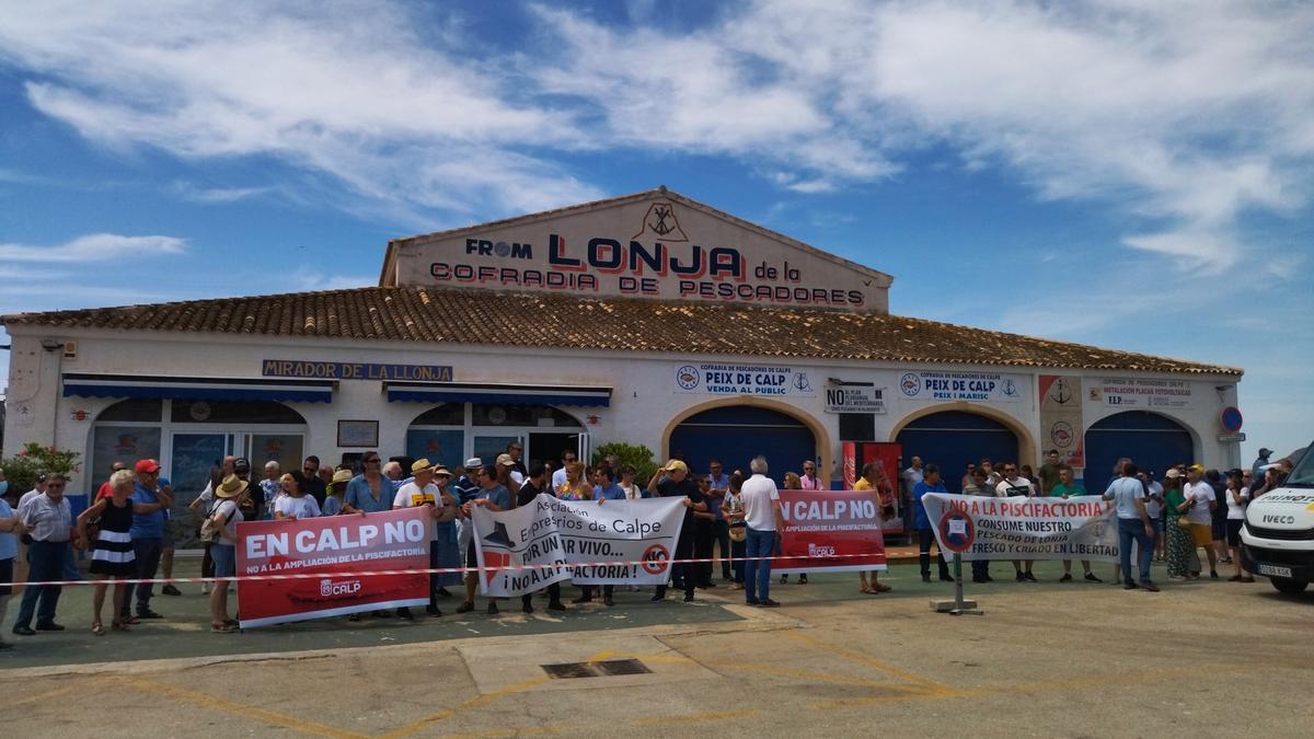 Algunos de los manifestantes sostienen las pancartas ante la lonja de pescadores