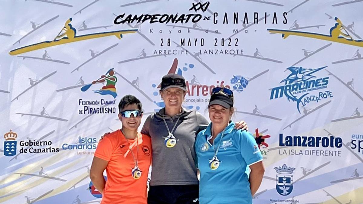 Judit Vergés, en el centro, luce su medalla de oro que la corona en cuarta ocasión como campeona de Canarias de surfski