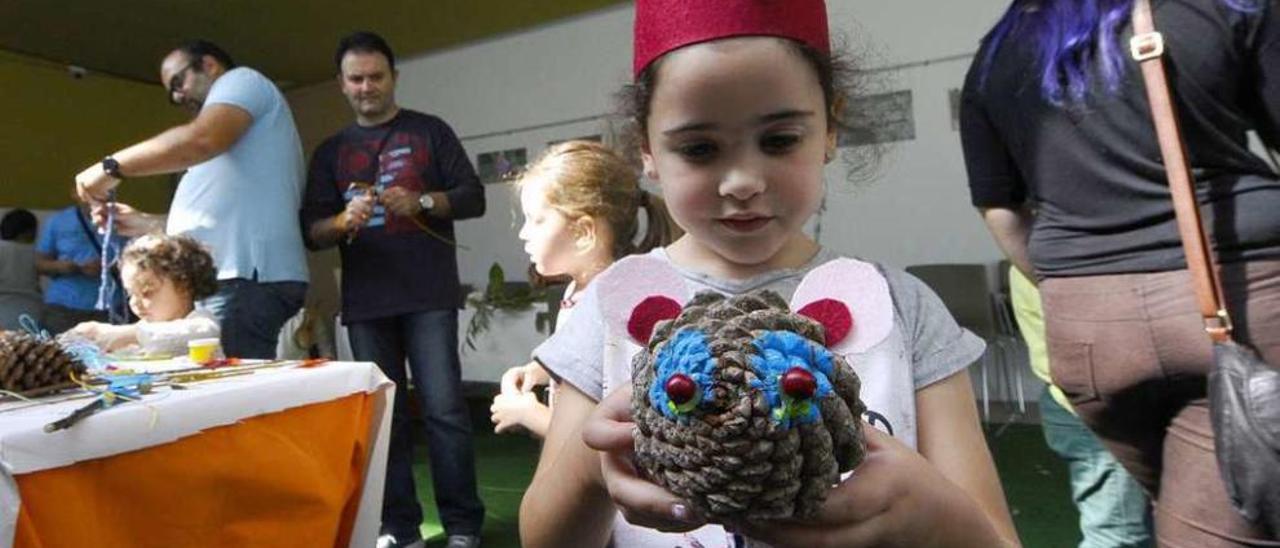 Una niña participante en el taller del Botánico muestra su juguete hecho por ella. // Jesús Regal