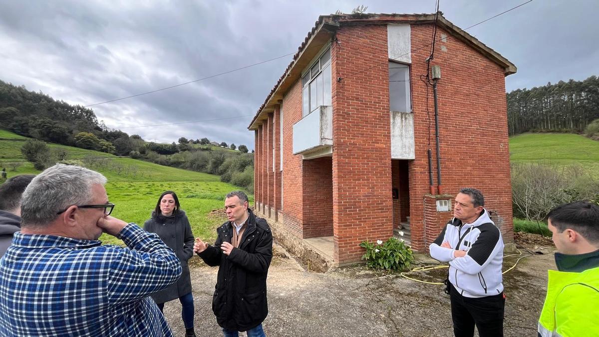 Reunión vecinal a las puertas de las antiguas escuelas de Bango.