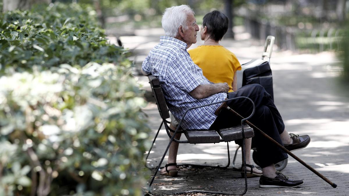 Un pensionista descansa en un banco de un parque de Madrid.