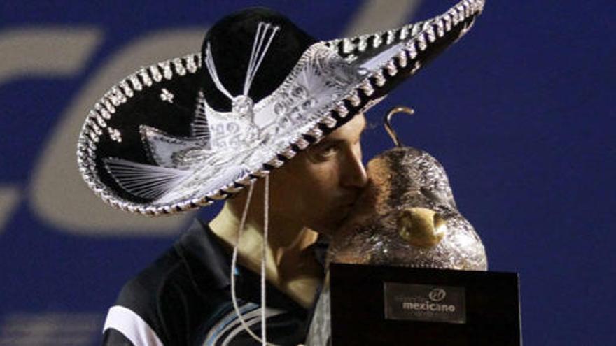 David Ferrer besa el trofeo que le acredita como ganador el torneo de Acapulco.