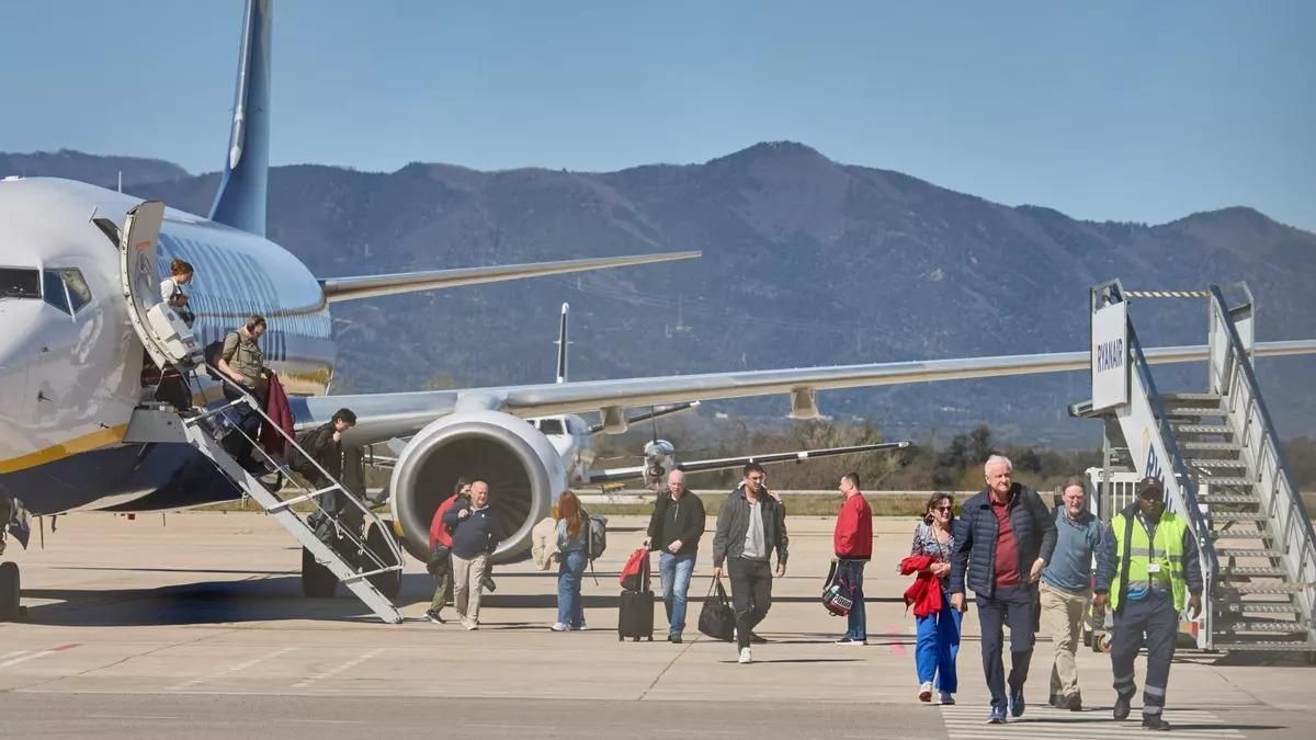 Turistes baixant dun avió a laeroport de Girona.