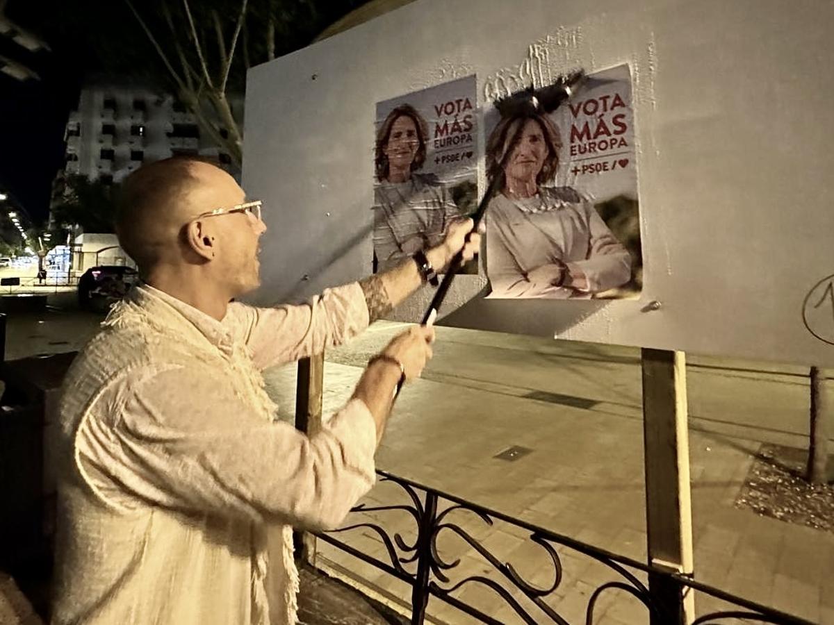 Piotr Sadowski pega un cartel electoral en Ibiza.