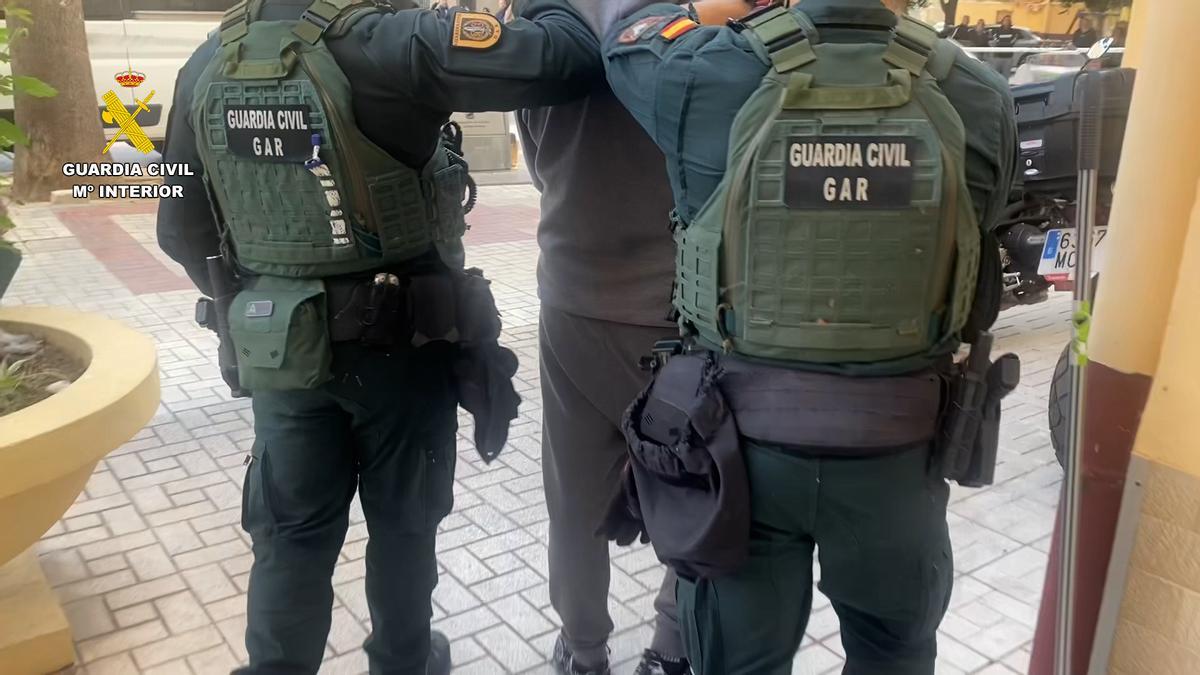 Agentes de la Guardia Civil detienen a uno de los cuatro miembros acusados de tráfico ilegal de armas.